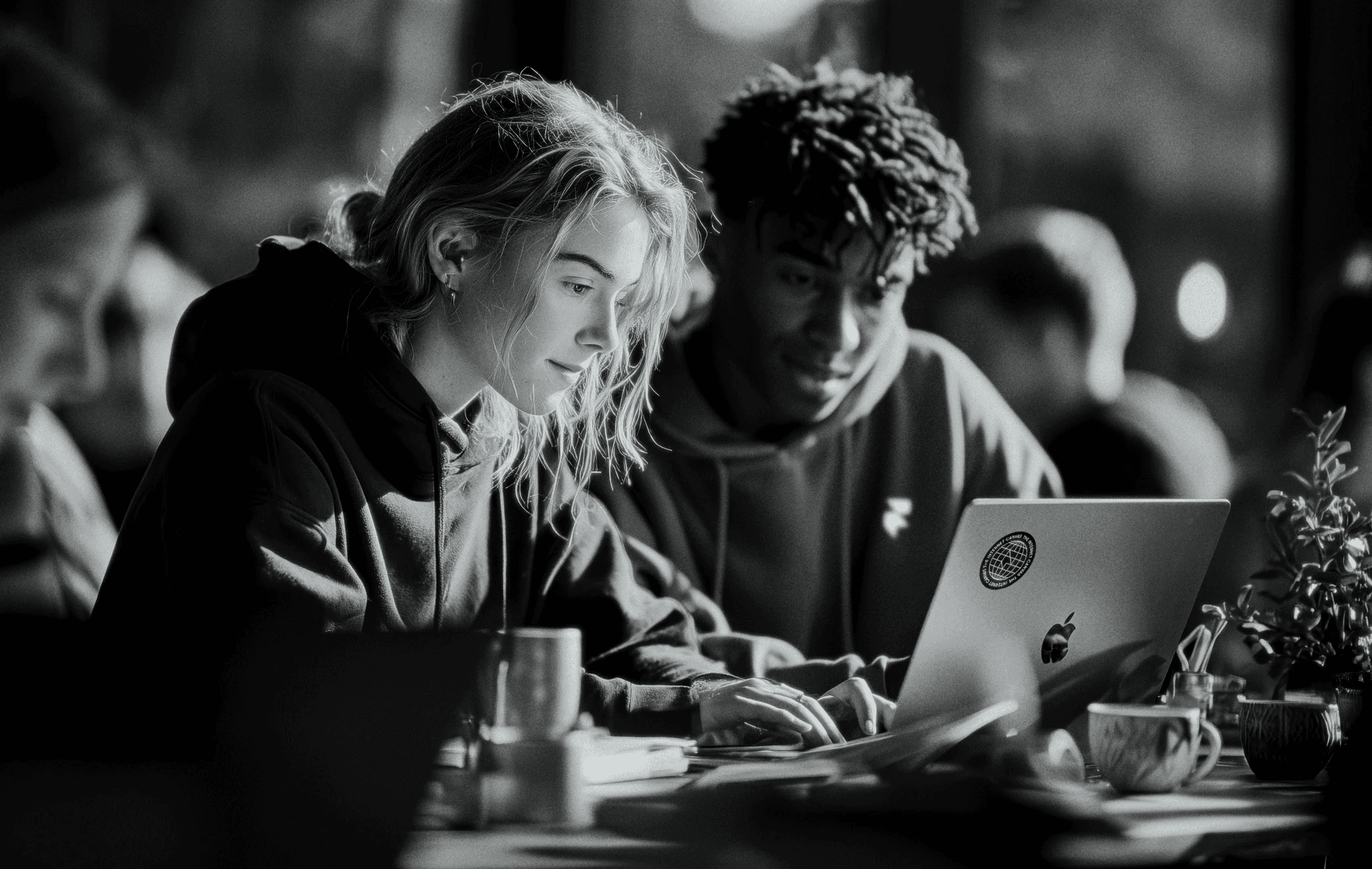 Two students working together on a laptop
